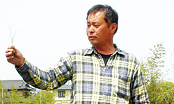 田植えを指導する事務局長の南川真毅さん